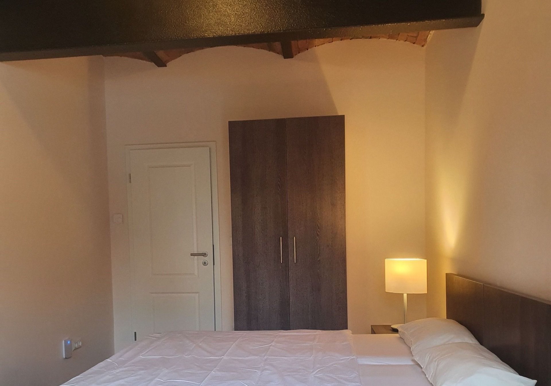 Doppelzimmer mit Doppelbett, historischem Backsteingewölbe und warmer Beleuchtung